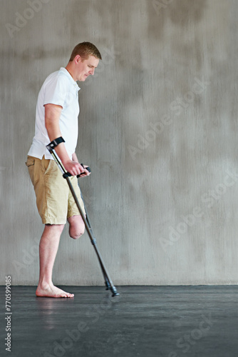 Physical therapy, patient with disability or amputee walking with crutches at clinic for recovery, strength and healthcare rehabilitation. Physiotherapy, support and consultation or workout for man photo