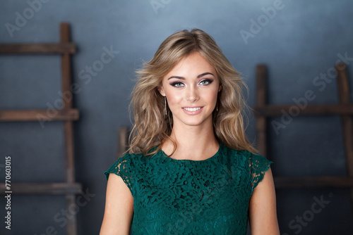 Happy young friendly woman smiling on blue background