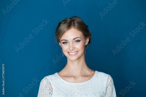 Cheerful young friendly woman smiling on blue background