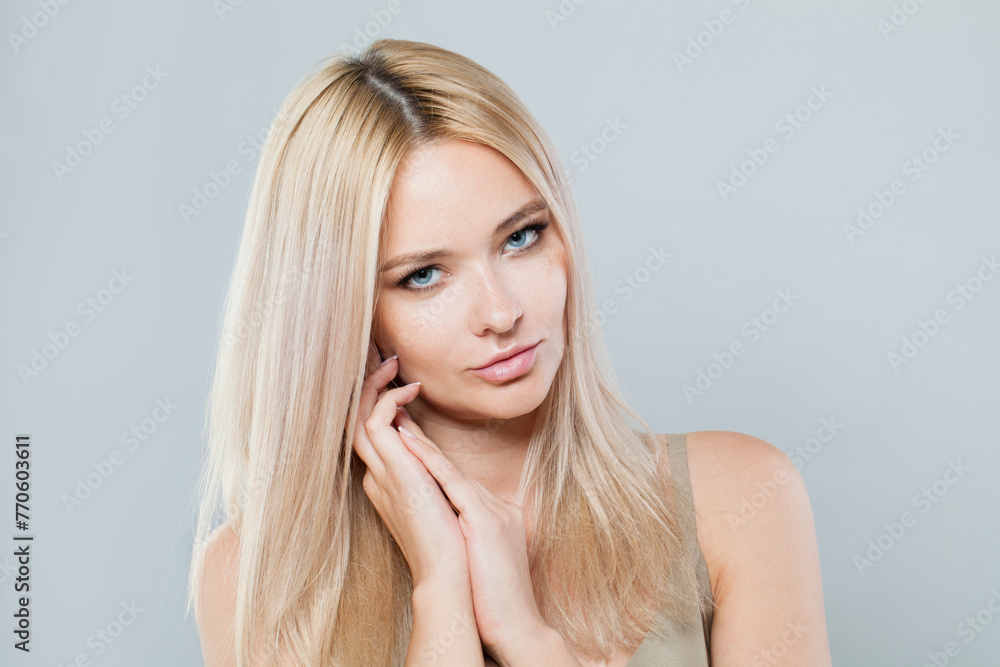 Charming blonde person portrait. Beauty woman with clear shiny fresh skin and blond hair on white background. Skincare, cosmetology and fashion concept - obrazy, fototapety, plakaty 