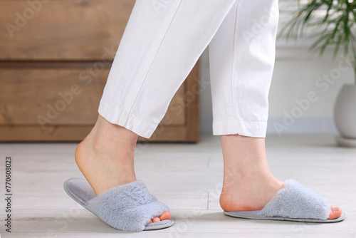 Woman in grey soft slippers at home, closeup