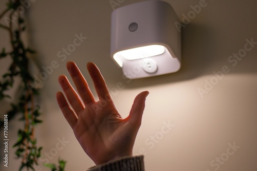closeup of a hand waving in front of a motion sensor light © altitudevisual