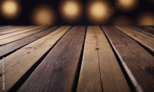 A close-up of a wooden surface is transformed into an artistic backdrop by a bokeh effect of warm, blurred lights. The soft glow creates a cozy, inviting atmosphere that complements the wood's texture
