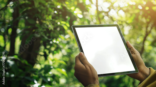 pessoa segurando um tablet nas mãos na floresta - mockup photo