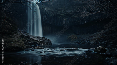 A night shot of a waterfall illuminated by moonlight casting a mystical glow.