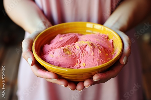 two children's hands are immersed in pink and yellow paint, evoking a sense of joy and creativity