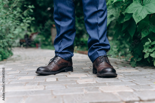 groom stands on path in park