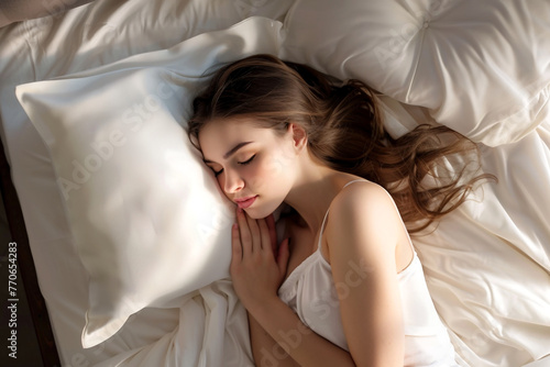 Sleeping woman in bed resting peacefully at home,surrounded by pillows, in the morning.World Sleep Day Concept.