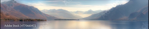 A mountain range with a lake in the foreground and a sky in the background photo