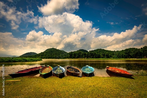 Fleet of small boats moored near Chandubi Lake, Kamrup, Assam, India photo