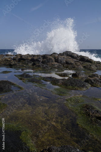 onda che si schianta sulle rocce della costa, scogli, con schizzi, spruzzi d'acqua che si proiettano per vari metri,dati dalla forza dell'impatto, onde dell'oceano atlantico,scattate a fuerteventura