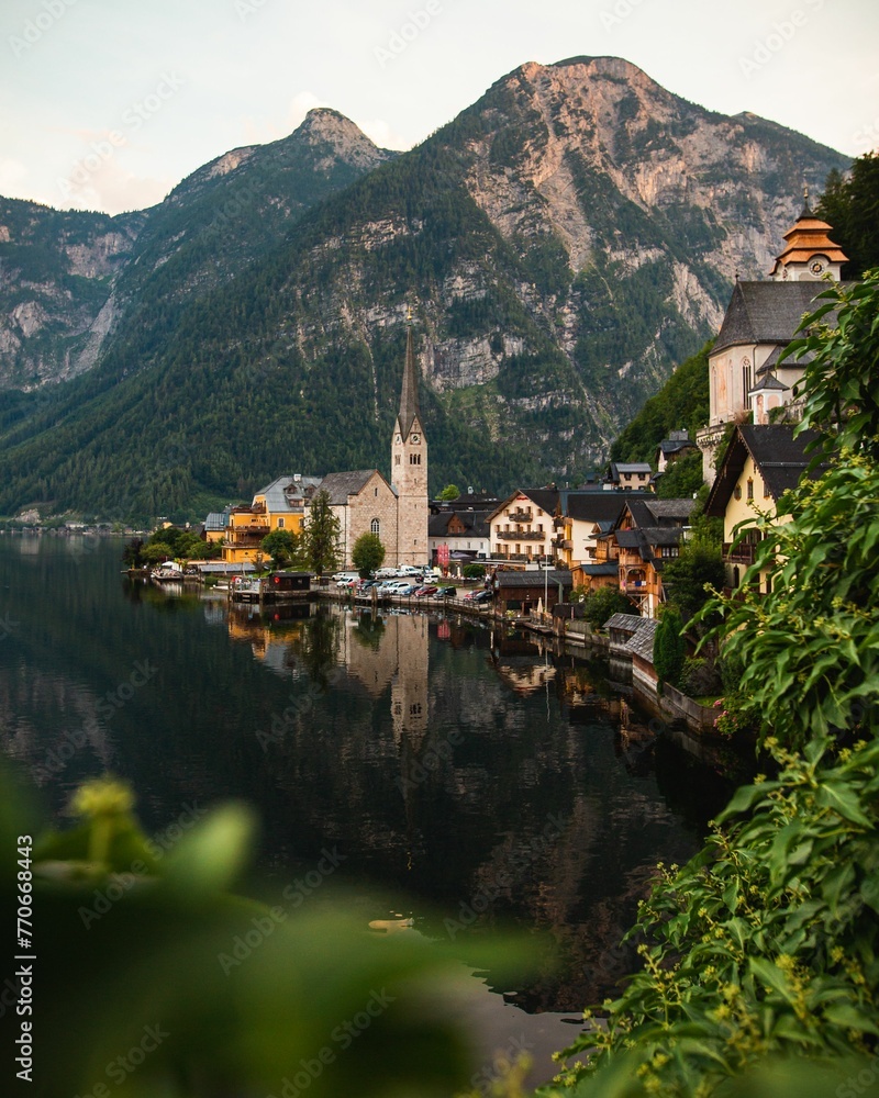 Fototapeta premium the village of hallsbach sits on the banks of a river surrounded by mountains