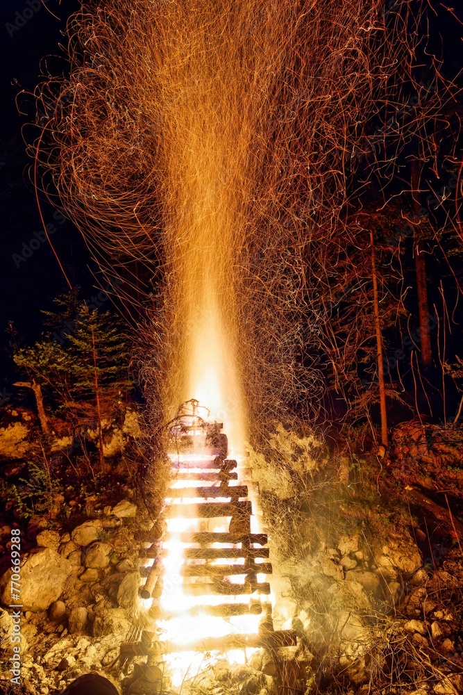 Obraz premium Vertical image of a large, blazing bonfire, with bright orange and yellow flames
