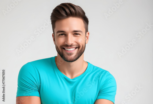 Smiling young Caucasian man with beard, wearing a turquoise t-shirt, representing concepts of health and wellness, suitable for Father's Day promotions