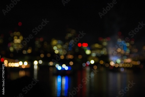 Blurred shot of a vibrant metropolitan cityscape at night, with the twinkling lights of buildings © Wirestock