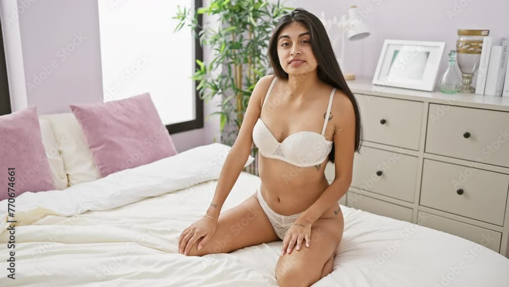 Attractive young south asian woman in lingerie posing seductively on her bed in a well-decorated bedroom Attractive young south asian woman in lingerie posing seductively on her bed in a well-decorated bedroom