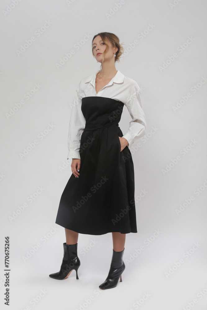 Serie of studio photos of female model wearing white button-down shirt under black tube top A line midi dress