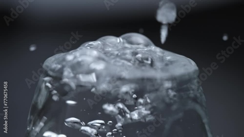 フルHD240pスーパースロー映像：ガラスコップにに水を注いで溢れる水面のアップ