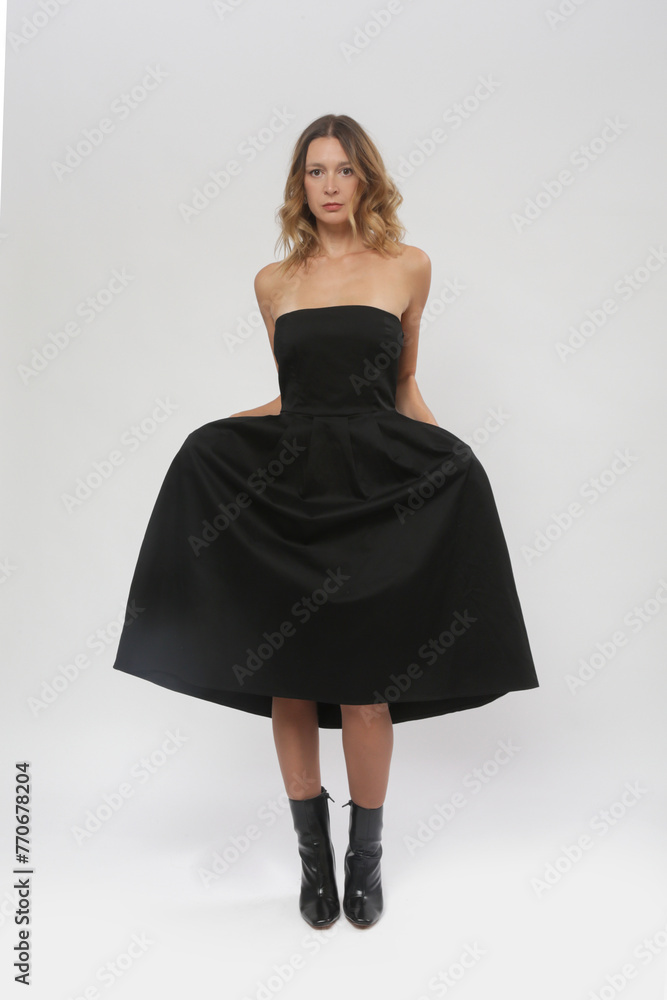 Serie of studio photos of female model in black tube top A line midi dress Serie of studio photos of female model in black tube top A line midi dress