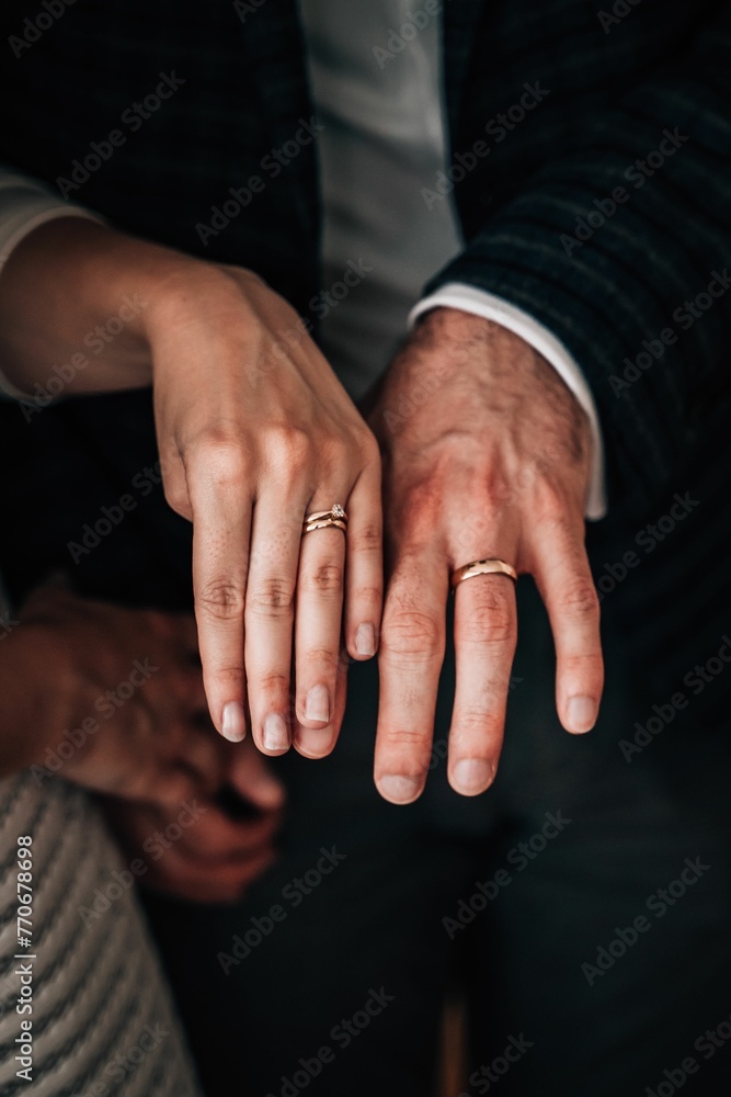 Closeup of a couple wearing engagement rings with a blurry background Closeup of a couple wearing engagement rings with a blurry background