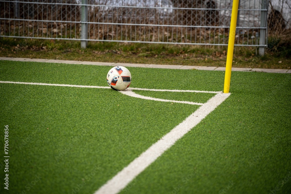 Soccer ball resting on a lush green grass field in the background of an outdoor setting Soccer ball resting on a lush green grass field in the background of an outdoor setting