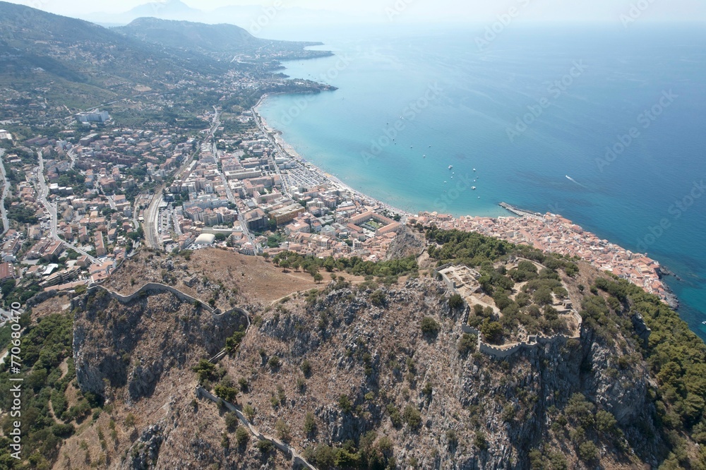 Aerial shot of Cefalu coastal town in Sicily overlooking the coastline and bay