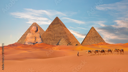 The great Sphinx of Giza in Egypt - Camel caravan in front of the Great pyramid of Giza complex - Cairo, Egypt