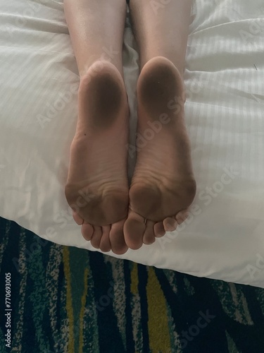 dirty feet on white clean bed