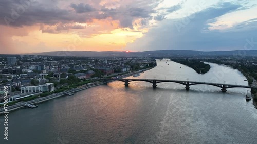 Ascending drone footage of Theodor Heuss Bridge and Mainz city on Rhine River in Germany at sunset photo