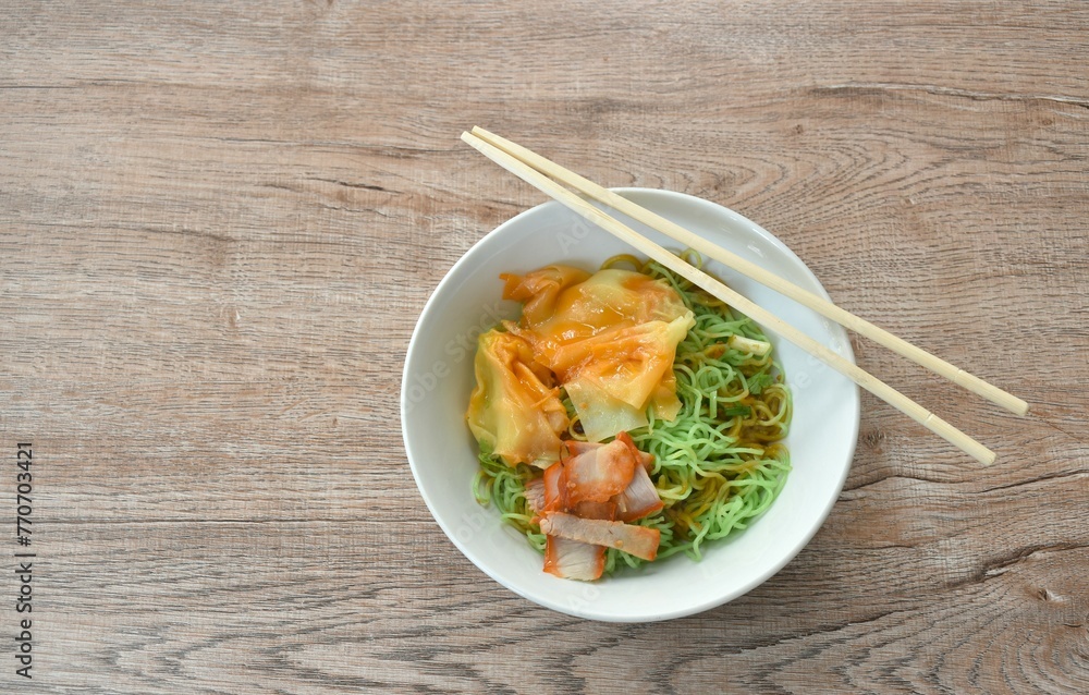 dry Chinese egg yellow noodles with barbecue pork and dumpling dressing sweet gravy red sauce on bowl dry Chinese egg yellow noodles with barbecue pork and dumpling dressing sweet gravy red sauce on bowl