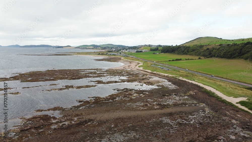 there is a very large grassy area with a small river in front of it there is a very large grassy area with a small river in front of it