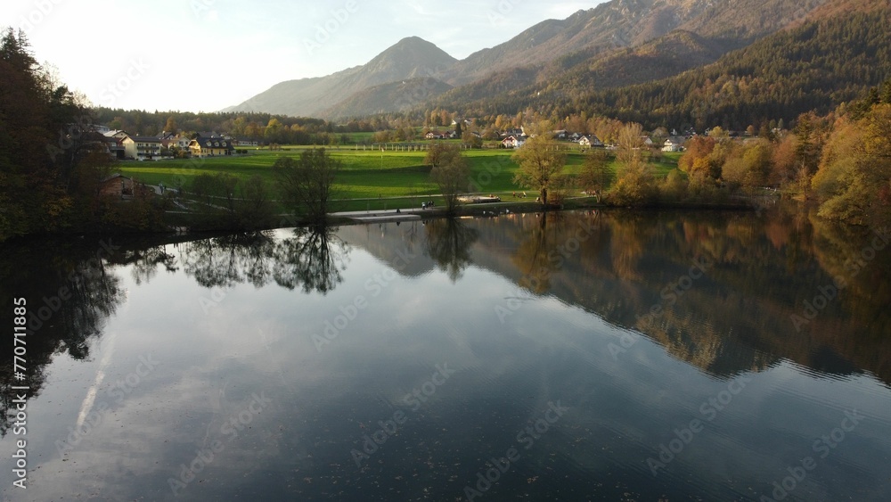 Aerial view of Lake Crnava surrounded by greenery on a sunny day in Slovenia