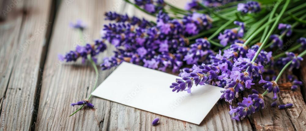 A cluster of fragrant lavender branches, their purple blossoms vibrant against the backdrop of a rustic wooden table, featuring a blank label for custom messaging. - obrazy, fototapety, plakaty 