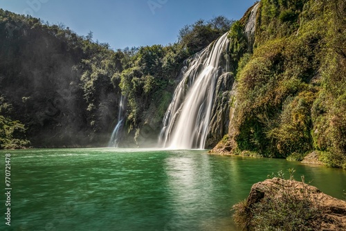 View of the Jiulong waterfall streaming down to a lake