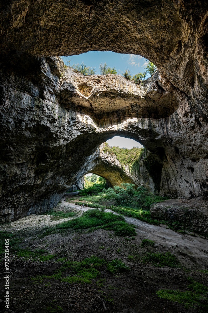 Stunning view of Devetashka Cave in Bulgaria, featuring rocky walls and natural holes.