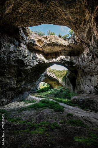Stunning view of Devetashka Cave in Bulgaria, featuring rocky walls and natural holes. © Wirestock