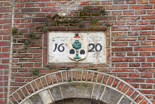 Obraz na płótnie Delft, the Netherlands. 17th century sign on the old building stating the construction date year 1620. w salonie