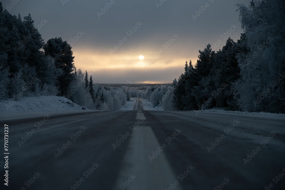 Obraz premium Majestic winter scene of a snow-covered landscape illuminated by a spectacular sunset sky.