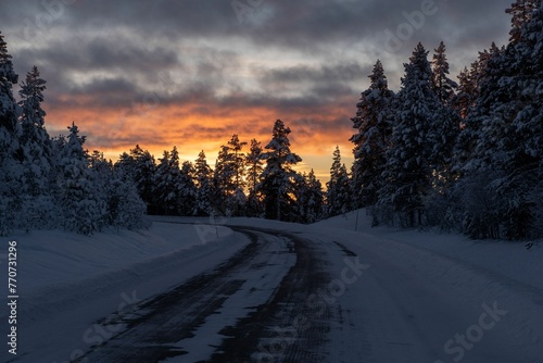 Majestic winter scene of a snow-covered landscape illuminated by a spectacular sunset sky. © Wirestock