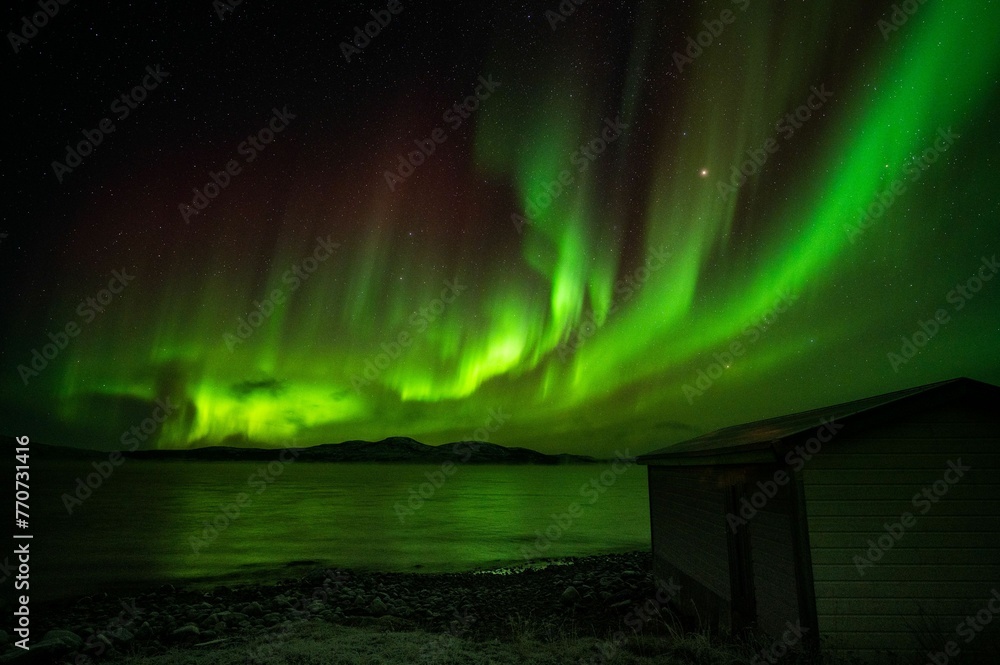 Stunning aurora borealis illuminating the night sky above the rural landscape. Stunning aurora borealis illuminating the night sky above the rural landscape.