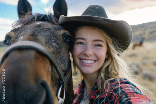 Smiling Young Woman in Cowboy Hat Posing with Horse on Ranch © gankevstock