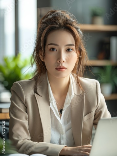 Young Asian businesswoman working on laptop in her office, the woman using her computer for work or study at her desk with a window and plant background. Free Download Young Asian businesswoman working on laptop in her office, the woman using her computer for work or study at her desk with a window and plant background. - GFXLoad