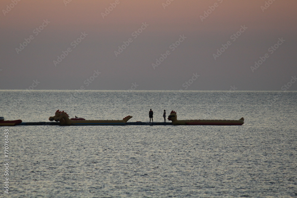 Naklejka premium silent scene of two people on water rides in the Black Sea early in the morning