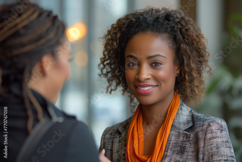 Close-up of a professional woman with a captivating smile engaging with a colleague in a corporate setting.