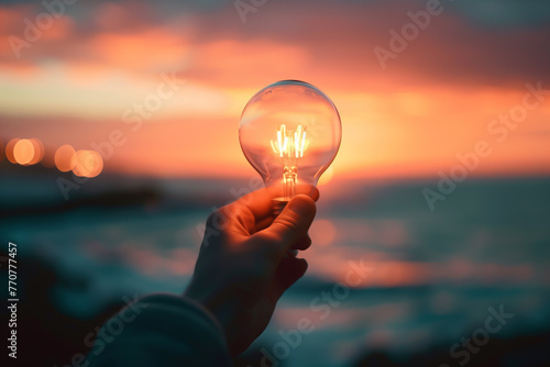 Person holding light bulb over ocean at sunset, electric lamp, idea, electricity, environment