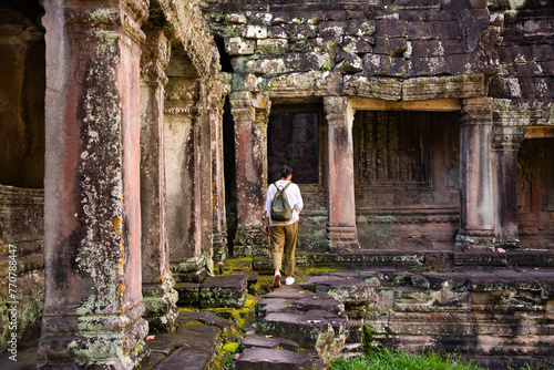 Female tourist looking at ancient Angkor temple in Cambodia