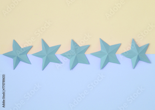 Five origami paper stars on pastel background. Service rating