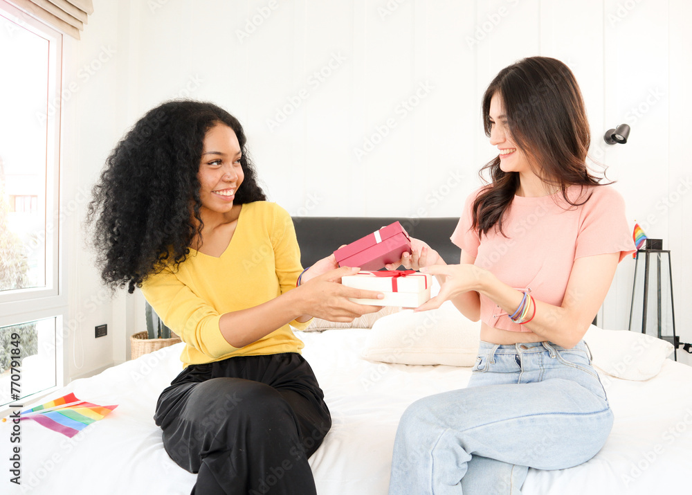 A multiracial young lesbian couple happily exchanging surprise gifts on special days such as anniversaries, Valentine's Day, New Year's Day, Christmas Day, birthdays, or congratulations A multiracial young lesbian couple happily exchanging surprise gifts on special days such as anniversaries, Valentine's Day, New Year's Day, Christmas Day, birthdays, or congratulations