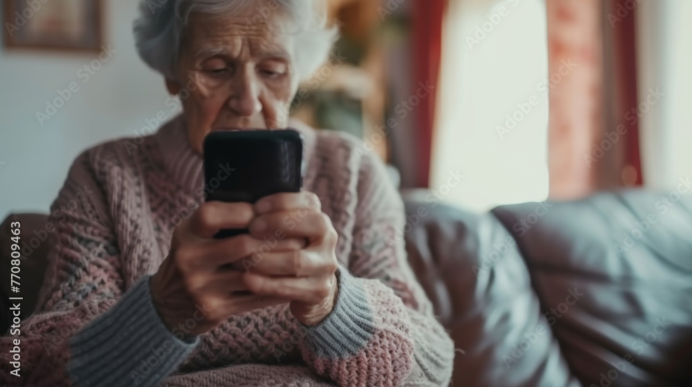 Fototapeta premium Happy senior female holding smartphone using mobile phone app. Technology, communication, happy adult woman with smartphone at home, recreation, communication, sociality, hobbies, adaptation