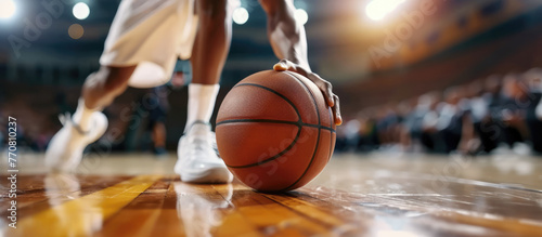 Basketball player is holding basketball ball on a court, close up photo 